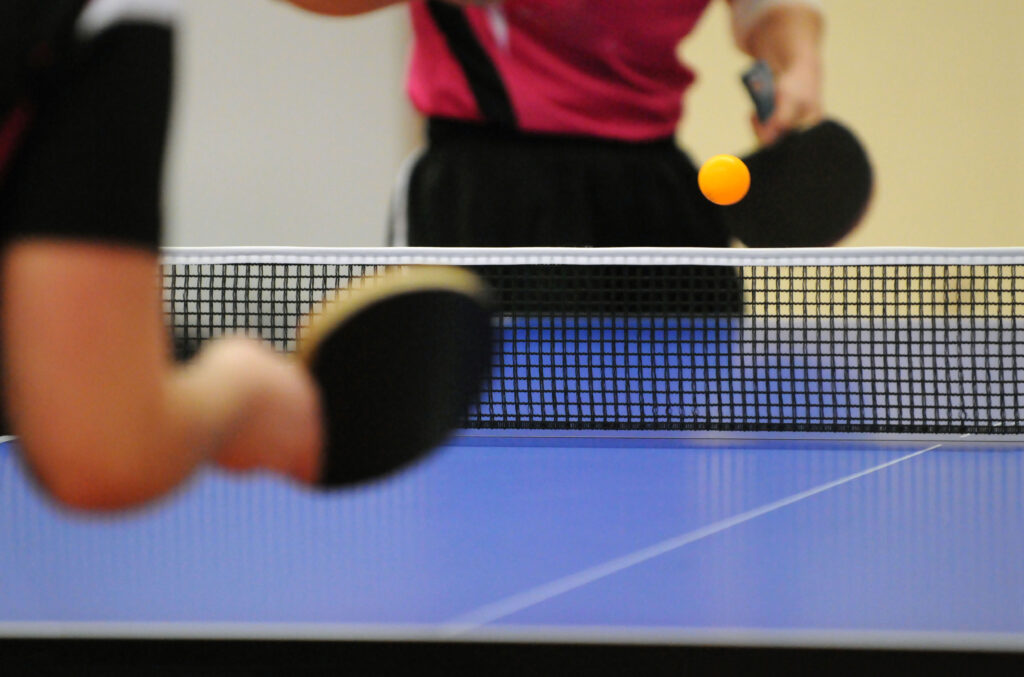 zwei Personen spielen an einem Tischtennistisch
